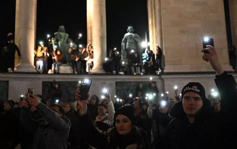 People light with their mobile phones as they demonstrate against Orban's government policies at the Heroes' Square in Budapest, Hungary on February 16, 2024. More than ten thousand people rallied on February 16 in Budapest responding to a controversy over a presidential pardon of a convicted child abuser's accomplice. Orban is facing his biggest political crisis since returning to power in 2010, following the shock resignations of two of his allies over a child sex abuse case. Hungary's President Novak and former Justice Minister Varga -- the ruling Fidesz party's most prominent women -- stepped down on February 10 over the pardoning of a convicted child abuser's accomplice. (Photo by ATTILA KISBENEDEK / AFP)