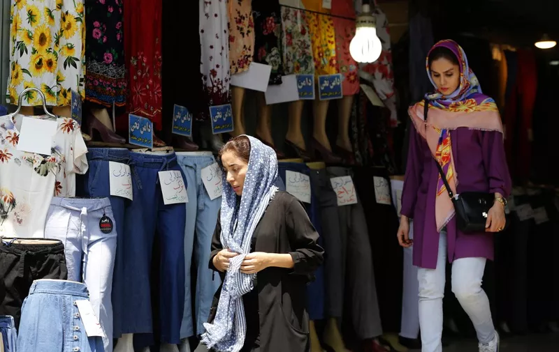 Women leave a clothing shop in the Iranian capital Tehran on August 6, 2018. - Iranian Foreign Minister Mohammad Javad Zarif said today that the leaders of the United States, Saudi Arabia and Israel were isolated in their hostility to Iran. (Photo by ATTA KENARE / AFP)