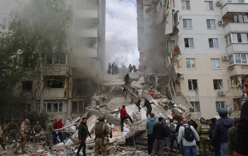 Firefighters and volunteers operate to secure the area on the site of a partially collapsed apartment building which was damaged by a Ukrainian strike in Belgorod on May 12, 2024. At least 20 people were injured, in the partial collapse of a building in Belgorod, after a Ukrainian strike, emergency services announced on May 12, 2024, after the Russian defence ministry said a Ukrainian Tochka-U missile hit a "residential district" in the city after it was intercepted by air defences. (Photo by STRINGER / AFP)