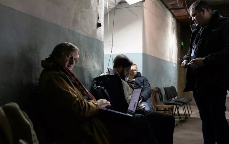 Choristers from the Ukrainian Radio Choir take refuge in the shelter of Kyiv's Radio House during an air alarm, in Kyiv, on December 22, 2023. The sound of "Carol of the Bells", part of western popular culture, is originated from an early bid for Ukrainian independence song called Shchedryk, or New Year's carol, written by composer Mykola Leontovych and first performed in Kyiv at Christmas 1916. The Kyiv concert on December 24, 2023 will recreate the first US concert performance of the Shchedryk, at the Carnegie Hall in New York, October 2022. (Photo by Florent VERGNES / AFP)