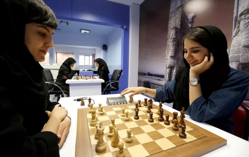 Iranian chess players Mitra Hejazipour (L) and Sara Khademalsharieh play at the Chess Federation in the capital Tehran on October 10, 2016. - For the Iranian players the veil is not a sign of oppression, they oppose a campaign launched in the United States against the holding of the Women's World Championship in February in Tehran. (Photo by ATTA KENARE / AFP)