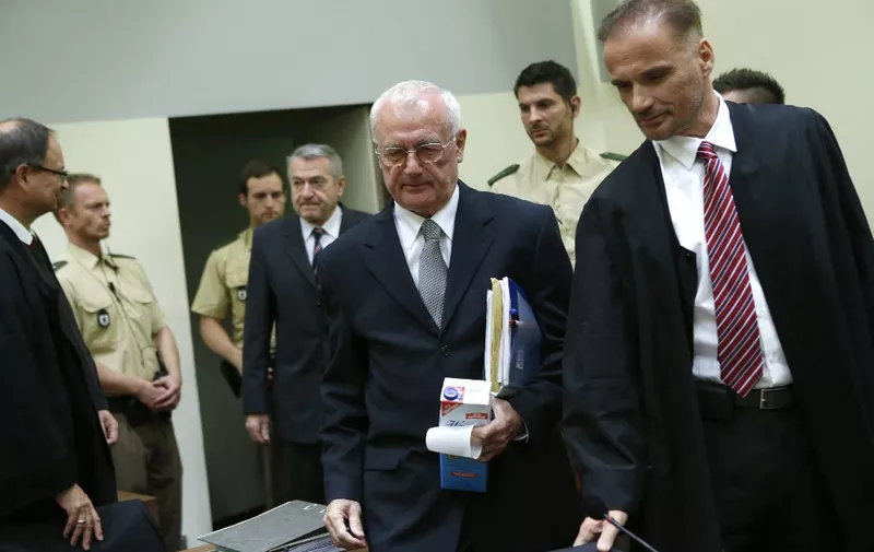 Josip Perkovic (3rd R) and Zdravko Mustac (4th L), former members of the Yugoslav secret service, arrive for their trial in a Munich courtroom October 17, 2014. Mustac and Perkovic are suspected of being involved in the murder of a Croatian emigrant in Germany. Yugoslav dissident Stjepan Djurekovic was murdered in 1983 near Munich, at a time when Perkovic was in the Yugoslav secret service in Germany. He was extradited to Germany at the beginning of this year on suspicion of masterminding the murder.     AFP PHOTO / POOL / MICHAELA REHLE (Photo by MICHAELA REHLE / POOL / AFP)