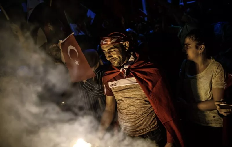 Pro-Erdogan supporters gather during a rally against the military coup on Taksim square in Istanbul on July 23, 2016. 
Turkey pushed on with a sweeping crackdown against suspected plotters of its failed coup, defiantly telling EU critics it had no choice but to root out hidden enemies. Using new emergency powers, President Recep Tayyip Erdogan's cabinet decreed that police could now hold suspects for one month without charge, and also announced it would shut down over 1,000 private schools it deems subversive.  / AFP PHOTO / OZAN KOSE