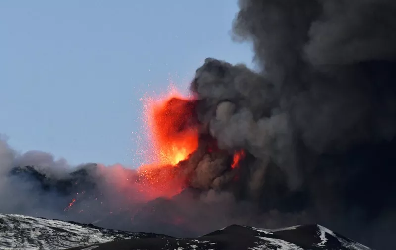 This photo obtained from Italian news agency ANSA shows the Etna volcano in Catania, Sicily, on February 16, 2021 during a spectacular eruption and a strong explosive activity from the south-east crater and the emission of a high cloud of lava ash that disperses towards the south. (Photo by Handout / ANSA / AFP) / Italy OUT
