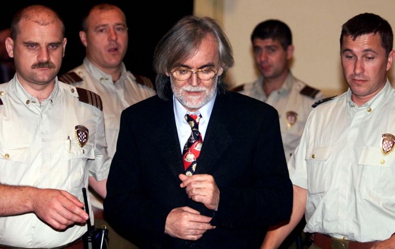 Bosnian Croat Mladen Naletilic (C), a suspected war criminal indicted by the tribunal in The Hague, is escorted by police 01 September 1999 as he arrives at court in Zagreb. The court is to decide on the extradition of Naletilic to The Hague. (ELECTRONIC IMAGE) (Photo by NIKOLA SOLIC / POOL / AFP)