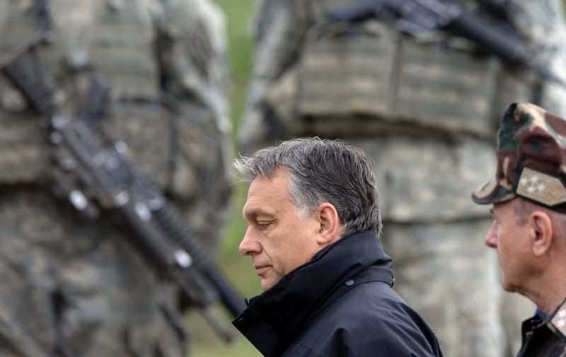 Hungarian Prime Minister Viktor Orban (C) walks in front of the US soldiers after a joint Hungarian-US military exercise near Osku village, Hungary, on October 2, 2014. The six-week exercise titled Joint Action 2014? with 1300 soldiers taking part, takes place from September 8 to October 17. AFP PHOTO / ATTILA KISBENEDEK