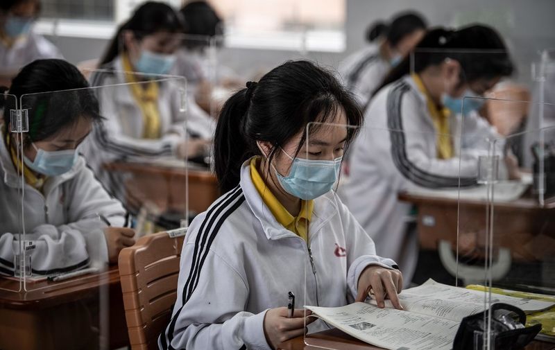 High school senior students study with plastic partitions in a classroom in Wuhan in China's central Hubei province on May 6, 2020. - Senior school students in 121 institutions were back in front of chalk boards and digital displays for the first time on May 6 since their city -- the ground zero of the coronavirus pandemic -- shut down in January. (Photo by STR / AFP) / China OUT