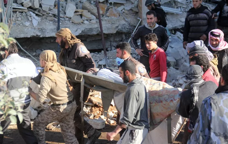 People carry a stretcher amidst debris after a hospital supported by Doctors Without Borders (MSF) was hit by suspected Russian air strikes near Maaret al-Numan, in Syria's northern province of Idlib, on February 15, 2016.
MSF confirmed in a statement that a hospital supported by the aid group in Idlib province was "destroyed in air strikes". / AFP / Omar haj kadour