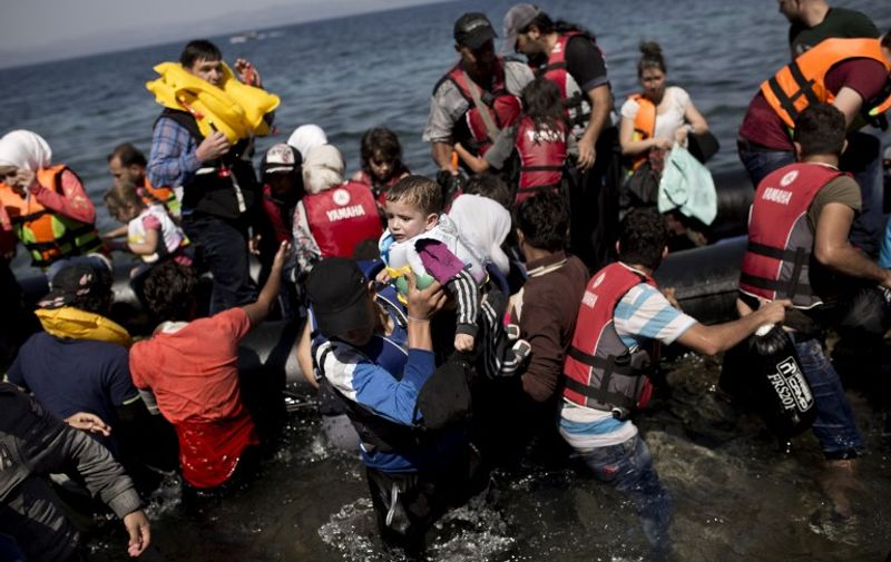 Syrian refugees arrive on the shores of the Greek island of Lesbos after crossing the Aegean Sea from Turkey on a inflatable dinghy on September 11, 2015. The EU unveiled plans to take 160,000 refugees from overstretched border states, as the United States said it would accept more Syrians to ease the pressure from the worst migration crisis since World War II. AFP PHOTO / ANGELOS TZORTZINIS