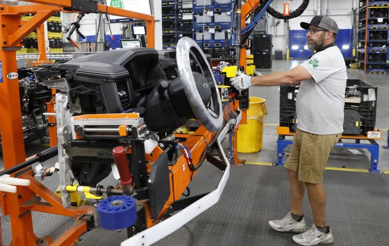 A worker installs the instrument cluster for the Ford Motor Co. battery powered F-150 Lightning trucks under production at their Rouge Electric Vehicle Center in Dearborn, Michigan on September 20, 2022. - Construction crews are back at Dearborn, remaking Ford's century-old industrial complex once again, this time for a post-petroleum era that is finally beginning to feel possible.
The manufacturing operation's prime mission in recent times has been to assemble the best-selling F-150, a gasoline-powered vehicle (Photo by JEFF KOWALSKY / AFP)