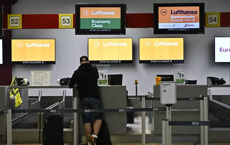 A man checks in at a desk of German airline Lufthansa at Berlins Tegel airport on June 11, 2020. - German airline Lufthansa said on June 11, 2020 that it would have to slash 22,000 full-time jobs as the recovery in demand for travel following the coronavirus pandemic will be muted. (Photo by Tobias SCHWARZ / AFP)