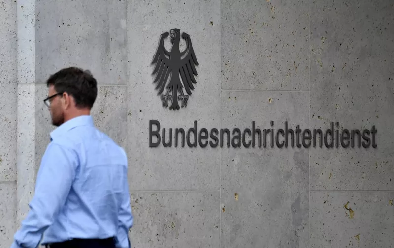A picture taken on May 19, 2020 shows an employee walking past the name of German Federal Intelligence Service (BND) at its headquartersin Berlin. Germany's foreign intelligence service (BND) is not allowed to spy on internet data from foreigners abroad, the country's top court ruled on May 19, 2020 siding with a complaint brought by journalists overseas. (Photo by John MACDOUGALL / AFP)