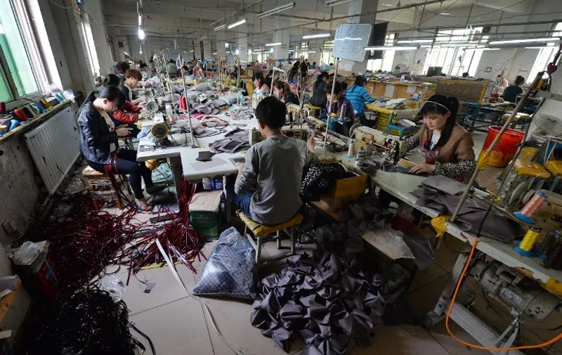 TO GO WITH China-economy-retail-Alibaba-family,FOCUS by Tom HANCOCK
This image taken on April 24, 2014 shows workers at a handbag factory completing orders to be sold through the Chinese internet e-commerce site Taobao in Baigou, Hebei Province.  The Alibaba Group, which dominates China's e-commerce market, combines aspects of eBay, Amazon, PayPal and other Western tech darlings, and according to analysts an investor frenzy could drive its value as high as 200 billion USD when it goes public in the US later this year.   One of Alibaba's main assets, the sprawling e-commerce site Taobao -- or "search for treasure" -- enables him to offer his locally made bags to millions of potential Chinese customers.              AFP PHOTO / Mark RALSTON