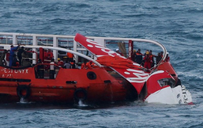 (FILES) In this file photograph taken on January 10, 2015, Indonesian search and rescue personnel pull wreckage of AirAsia flight QZ8501 onto the Crest Onyx ship at sea. A fault with the rudder control system was a major factor in the December 2014 AirAsia plane crash into the Java Sea that left 162 people dead, Indonesian investigators said on December 1, 2015. AFP PHOTO / FILES / AFP / STR