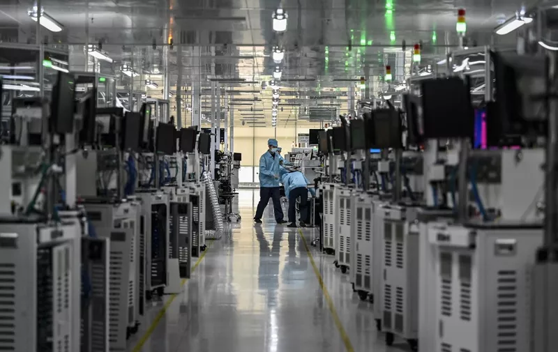 This photo taken on July 20, 2022 shows employees working on a smartphone production line at the Oppo factory in Dongguan, China's southern Guangdong province. (Photo by Jade GAO / AFP)