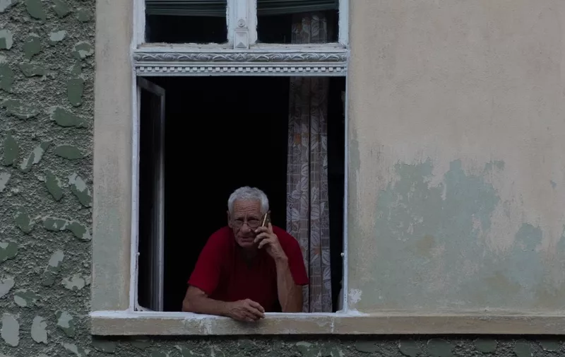 A man talks on his cell phone on his balcony, in Brasov, Romania.