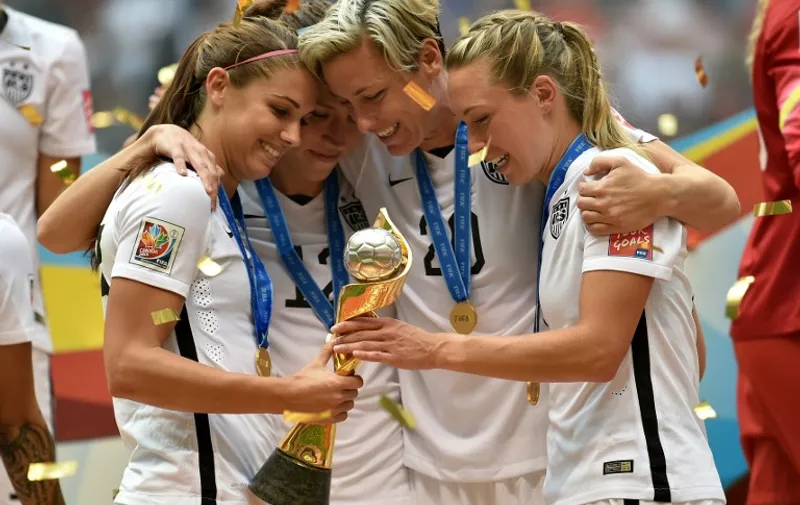 VANCOUVER, BC - JULY 05: Alex Morgan #13, Lauren Holiday #12, Abby Wambach #20 and Whitney Engen #6 of the United States of America hold the World Cup Trophy after their 5-2 win over Japan in the FIFA Women's World Cup Canada 2015 Final at BC Place Stadium on July 5, 2015 in Vancouver, Canada.   Rich Lam/Getty Images/AFP