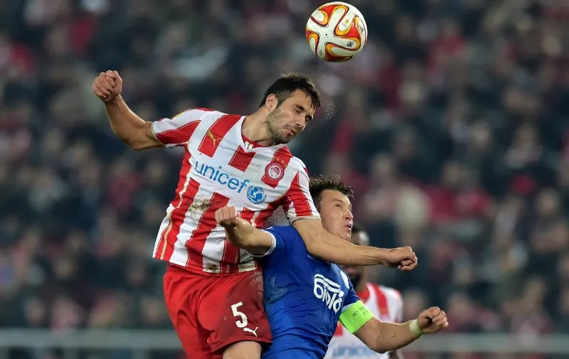 FC Dnipro' Ukrainian midfielder Ruslan Rotan (R) and Olympiacos' Serbian midfielder Luka Milivojevic go for a header during the UEFA Europa League Round of 32 football match Olympiacos vs Dnipro in Athens on February 26, 2015. AFP PHOTO / ARIS MESSINIS