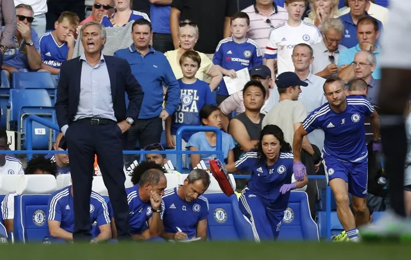Chelsea doctor (2R) Eva Carneiro and head physio Jon Fearn (R) leave the bench to treat Chelsea's Belgian midfielder Eden Hazard late in the game as Chelsea's Portuguese manager Jose Mourinho (L) gestures during the English Premier League football match between Chelsea and Swansea City  at Stamford Bridge in London on August 8, 2015. Chelsea have sidelined team doctor Eva Carneiro from match-day duties after she fell foul of manager Jose Mourinho, according to British media reports on August 11, 2015. Mourinho criticised Carneiro after she ran on the pitch to treat Eden Hazard in stoppage time of Chelsea's 2-2 draw at home to Swansea City on August 8, saying she did not "understand the game". AFP PHOTO / IAN KINGTON

RESTRICTED TO EDITORIAL USE. No use with unauthorized audio, video, data, fixture lists, club/league logos or 'live' services. Online in-match use limited to 75 images, no video emulation. No use in betting, games or single club/league/player publications.