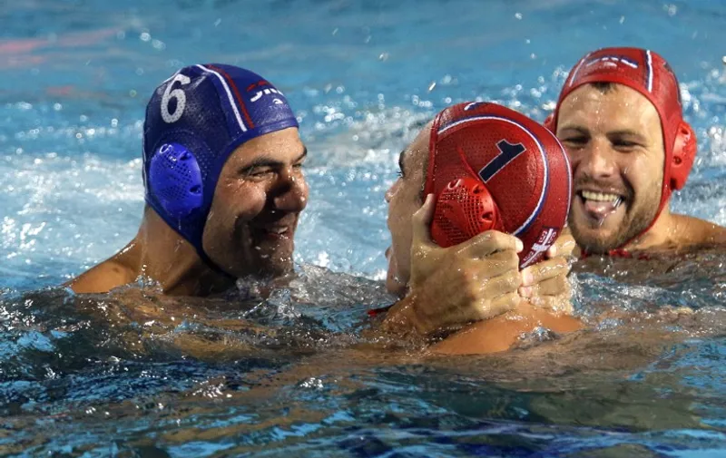 Serbia's goalkeepers, Gojko Pijetlovic (C) and Bronislaw Mitrovic (R) and Serbia's player Dusko Pijetlovic (L) react after winning the Water Polo European Championships for men's final Hungary vs Serbia in Budapest on July 27, 2014.   AFP PHOTO / PETER KOHALMI / AFP / PETER KOHALMI