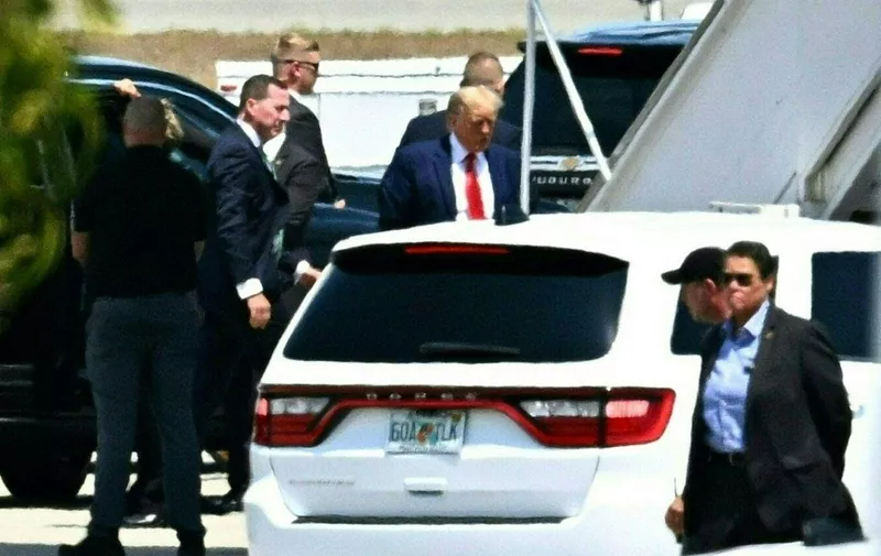 Former US President Donald Trump boards his plane at Palm Beach International Airport in West Palm Beach, Florida, on April 3, 2023. - Former US President Donald Trump is to be booked, fingerprinted, and will have a mugshot taken at a Manhattan courthouse on the afternoon of April 4, 2023, before appearing before a judge as the first ever American president to face criminal charges. Trump left his Mar-a-Lago residence in a dozen-vehicle motorcade as a dozen supporters shouted as the former president passed by to show their support for him. (Photo by CHANDAN KHANNA / AFP)