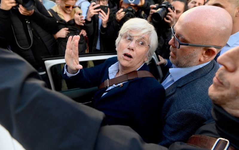 Catalan regional policeman 'Mosso D'Esquadra" detains former Education minister of Catalonia and MEP's Clara Ponsati (C), flanked by her lawyer Gonzalo Boye (R), upon her come back in Spain after 5 years into exile, in Barcelona on March 28, 2023. - Ponsati has come back in Spain after 5 years into exile following a failed 2017 Catalonia's independence bid that sparked Spain's worst political crisis in decades. A reform of Spain's criminal code in December 2022 has abolished the offence of sedition and replaced it with the charge of public disorder, which carries softer penalties. (Photo by Josep LAGO / AFP)