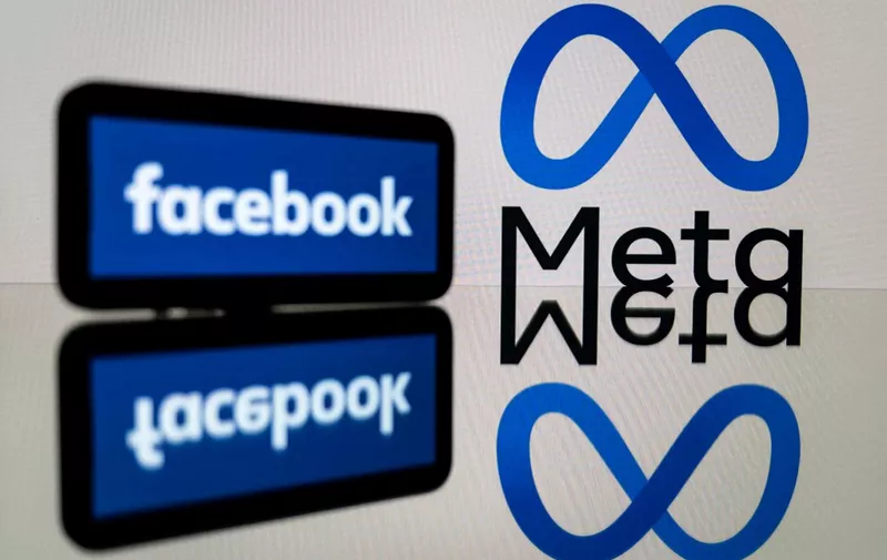 This picture taken on January 12, 2023 in Toulouse, southwestern France shows a smartphone and a computer screen displaying the logos of the social network Facebook and its parent company Meta. (Photo by Lionel BONAVENTURE / AFP)