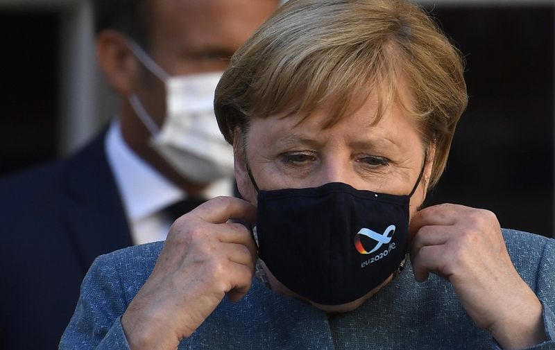 German Chancellor Angela Merkel wears a face mask as she arrives with French president Emmanuel Macron for a press conference after a meeting at Fort de Bregancon, in Bormes-les-Mimosas, south-east of France, on August 20, 2020. - French president Emmanuel Macron meets German Chancellor Angela Merkel to try to strengthen the understanding of the Franco-German couple on the many hot European and international issues. (Photo by CHRISTOPHE SIMON / POOL / AFP)