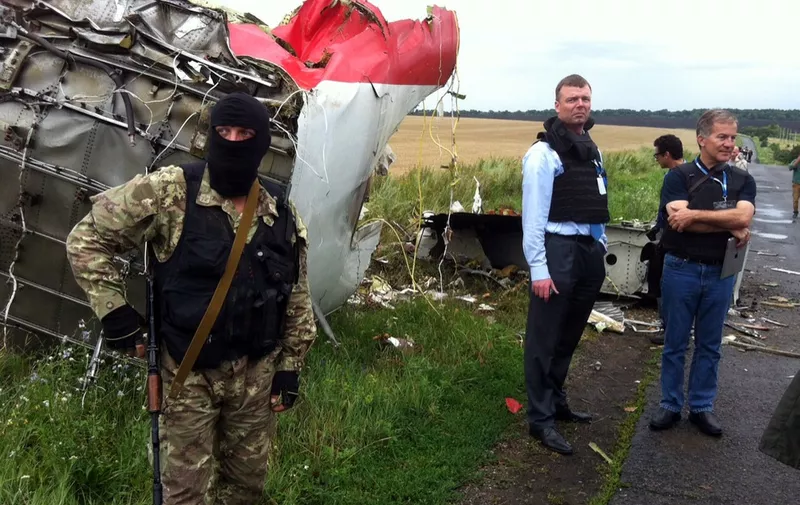 Alexander Hug (2nd L), Deputy Chief Monitor of the Organization for Cooperation and Security in Europe's  (OSCE) Special Monitoring Mission to Ukraine, visits the site of the crash of a Malaysian airliner carrying 298 people from Amsterdam to Kuala Lumpur, near the town of Shaktarsk, in rebel-held east Ukraine, on July 18, 2014. Pro-Russian separatists in the region and officials in Kiev blamed each other for the crash, after the plane was apparently hit by a surface-to-air missile. All 298 people on board Flight MH17 died when the plane crashed. AFP PHOTO / DOMINIQUE FAGET (Photo by DOMINIQUE FAGET / AFP)