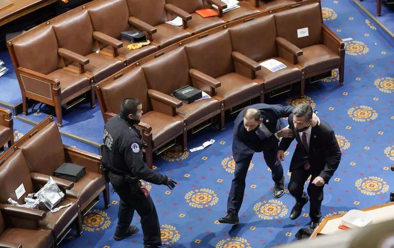 WASHINGTON, DC - JANUARY 06: Members of congress run for cover as protesters try to enter the House Chamber during a joint session of Congress on January 06, 2021 in Washington, DC. Congress held a joint session today to ratify President-elect Joe Biden's 306-232 Electoral College win over President Donald Trump. A group of Republican senators said they would reject the Electoral College votes of several states unless Congress appointed a commission to audit the election results.   Drew Angerer/Getty Images/AFP