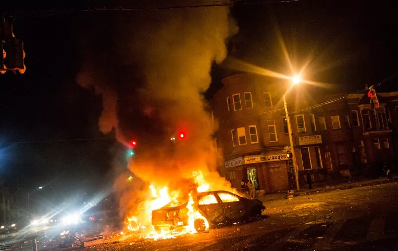 BALTIMORE, MD - APRIL 27: Two cars burn in the middle of an intersection at New Shiloh Baptist Church on April 27, 2015 in Baltimore, Maryland. Riots have erupted in Baltimore following the funeral service for Freddie Gray, who died last week while in Baltimore Police custody.   Andrew Burton/Getty Images/AFP