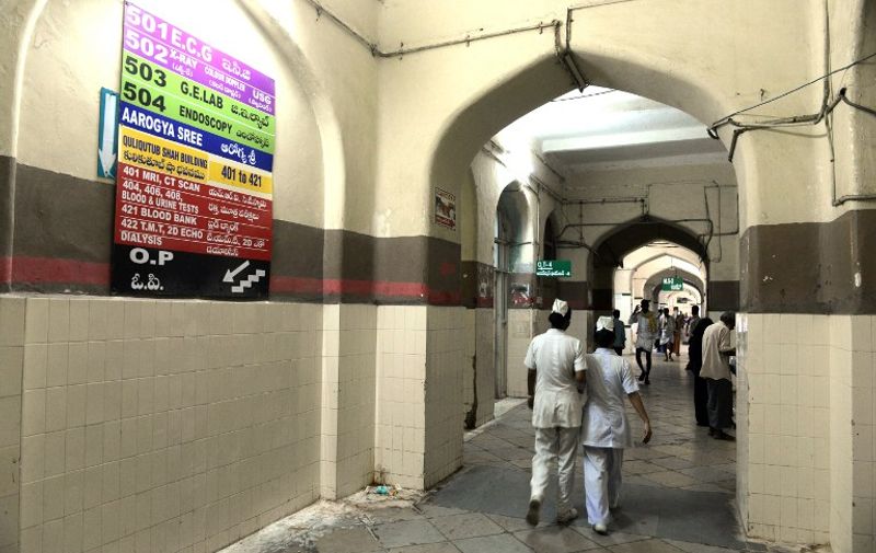 In this photograph taken on July 29, 2015, Indian nurses walk in a corridor at Osmania General Hospital (OGH) in Hyderabad. The hospital, which was completed in 1919 was designed by British architect Vincent Esch for Mir Osman Ali Khan and is an example of the blending of Indian and European architecture popular in the early twentieth century now faces demolition by the Telangana government which has prompted debate on social media among many including Bollywood personalities and international authors.     AFP PHOTO/NOAH SEELAM / AFP / NOAH SEELAM