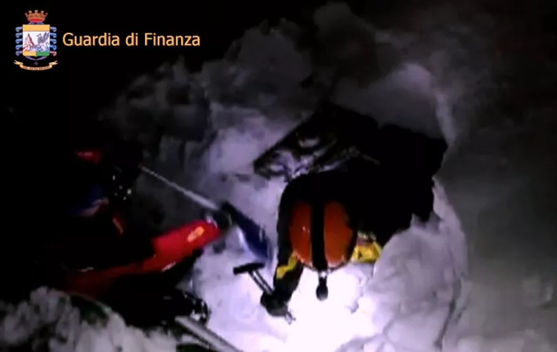 This image grab made from a video handout released by the Guardia di Finanza on January 19, 2017 shows rescue team members digging the snow at the Hotel Rigopiano engulfed by a powerful avalanche near the village of Farindola, on the eastern lower slopes of the Gran Sasso mountain.
Up to 30 people were feared to have died after an Italian mountain Hotel Rigopiano was engulfed by a powerful avalanche in the earthquake-ravaged centre of the country. Italy's Civil Protection agency confirmed the Hotel Rigopiano had been engulfed by a two-metre (six-feet) high wall of snow and that emergency services were struggling to get ambulances and diggers to the site.
 / AFP PHOTO / Guardia di Finanza press office / Handout / RESTRICTED TO EDITORIAL USE - MANDATORY CREDIT "AFP PHOTO / GUARDIA DI FINANZA HANDOUT" - NO MARKETING NO ADVERTISING CAMPAIGNS - DISTRIBUTED AS A SERVICE TO CLIENTS