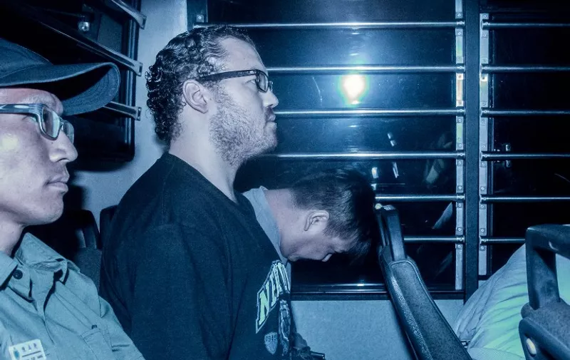 British banker Rurik Jutting (2nd L), accused of the murders of two Indonesian women, sits in a prison van as he arrives at the eastern court in Hong Kong on May 8, 2015. Jutting on May 8 returned to court for a hearing. AFP PHOTO / ANTHONY WALLACE / AFP PHOTO / ANTHONY WALLACE