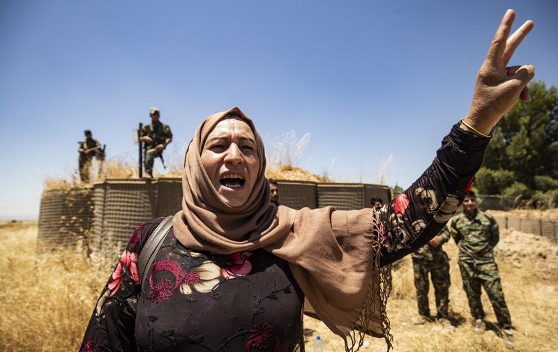 A Syrian Kurdish woman chants slogans during a demonstration in front of a US base in the countryside of the Hasakeh province, on June 27, 2020, to protest Turkish deadly offensives in the northeastern areas of the country. (Photo by Delil SOULEIMAN / AFP)