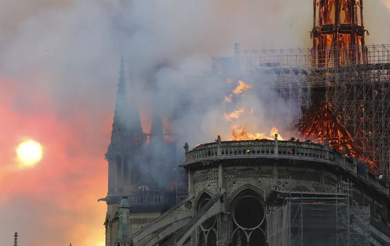 Smoke billows as flames destroy the roof of the landmark Notre-Dame Cathedral in central Paris on April 15, 2019. - A major fire broke out at the landmark Notre-Dame Cathedral in central Paris sending flames and huge clouds of grey smoke billowing into the sky, the fire service said. The flames and smoke plumed from the spire and roof of the gothic cathedral, visited by millions of people a year, where renovations are currently underway. (Photo by FRANCOIS GUILLOT / AFP)