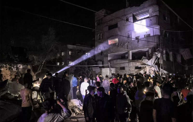 People gather around a building that was hit by Israeli bombardment in Rafah in the southern Gaza Strip on May 7, 2024 amid the ongoing conflict in the Palestinian territory between Israel and the militant group Hamas. (Photo by AFP)
