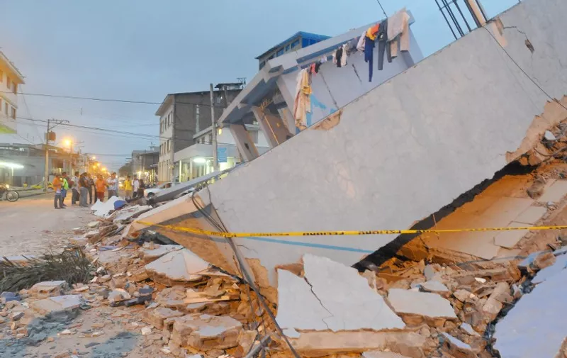 People gather next to a collapsed house in Guayaquil on April 17, 2016.
At least 41 people have  been killed by the powerful earthquake that struck western Ecuador on Saturday and the toll will likely rise further, the country's Vice President Jorge Glas said. / AFP PHOTO / JOSE SANCHEZ L