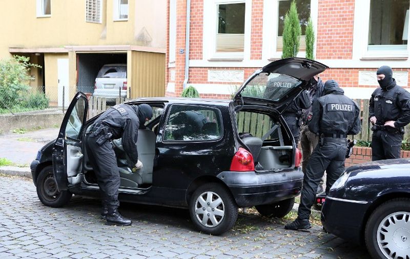 Police inspectors search a car on August 10, 2016 in Hildesheim. 
Police conducted searches in different locations of the German state of the North Rhine-Westphalia in relation to the Islamc State group connections. / AFP PHOTO / dpa / Christian Gossmann / Germany OUT