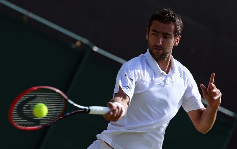 Croatia's Marin Cilic returns to US player Denis Kudla during their men's singles fourth round match on day seven of the 2015 Wimbledon Championships at The All England Tennis Club in Wimbledon, southwest London, on July 6, 2015.   RESTRICTED TO EDITORIAL USE  -- AFP PHOTO / JUSTIN TALLIS