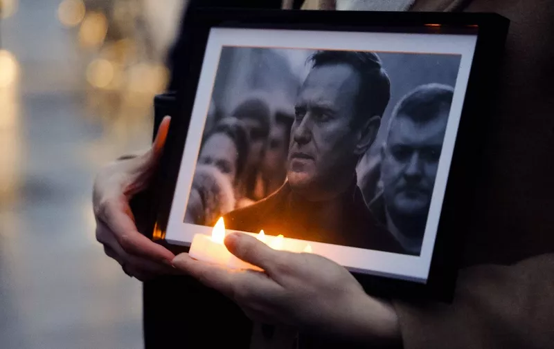 (FILES) A protester holds candles and a picture of the late opposition leader Alexei Navalny, during a demonstration organised by the association "Russie-Libertes" at the Esplanade du Trocadero in Paris, on February 22, 2024. Russian opposition leader Alexei Navalny's funeral service will be held at a church in southern Moscow on March 1st 2024, allies of the politician said. "Alexei's funeral will be held in a church ... in Maryino on 1 March at 14:00 (1100 GMT). Come in advance," his team said in a social media post on February 28, 2024. (Photo by Ludovic MARIN / AFP)