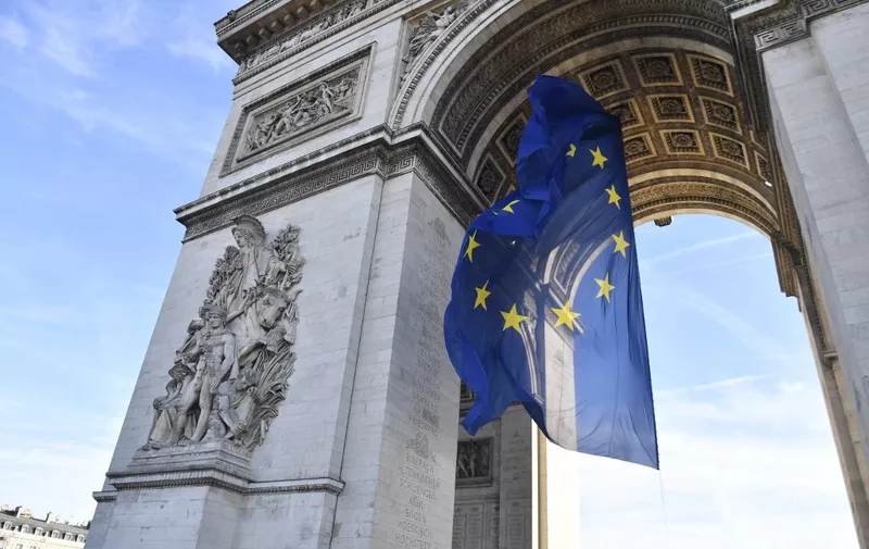 A picture taken on January 1, 2022 shows the European Union flag under the Arc de Triomphe, on the Place de l'Etoile in Paris. (Photo by Alain JOCARD / AFP)