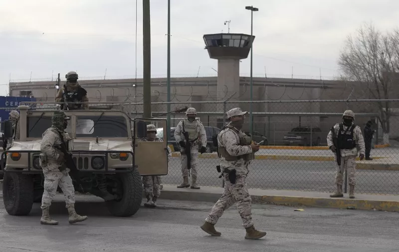 Members of the Mexican Army secure an area outside the prison of Ciudad Juarez number 3 after an attack in Ciudad Juarez, Chihuahua state, on January 1, 2023. - Gunmen attacked a prison in the northern Mexican city of Ciudad Juarez on Sunday, leaving 14 people dead and allowing 24 inmates to escape, the Chihuahua state prosecutor's office said. An unknown number of gunmen aboard armoured vehicles took part in the attack, and the dead included ten correctional officers and security agents, it said in a statement. (Photo by HERIKA MARTINEZ / AFP)