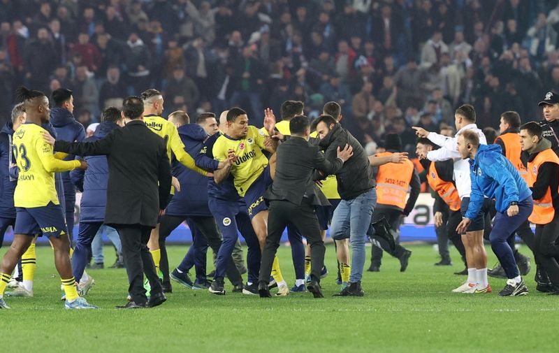 Soccer Football - Super Lig - Trabzonspor v Fenerbahce - Papara Park, Trabzon, Turkey - March 17, 2024 Trabzonspor fans invade the pitch and clash with Fenerbahce players and security staff after the match. REUTERS/Depo Photos  TURKEY OUT. NO COMMERCIAL OR EDITORIAL SALES IN TURKEY.