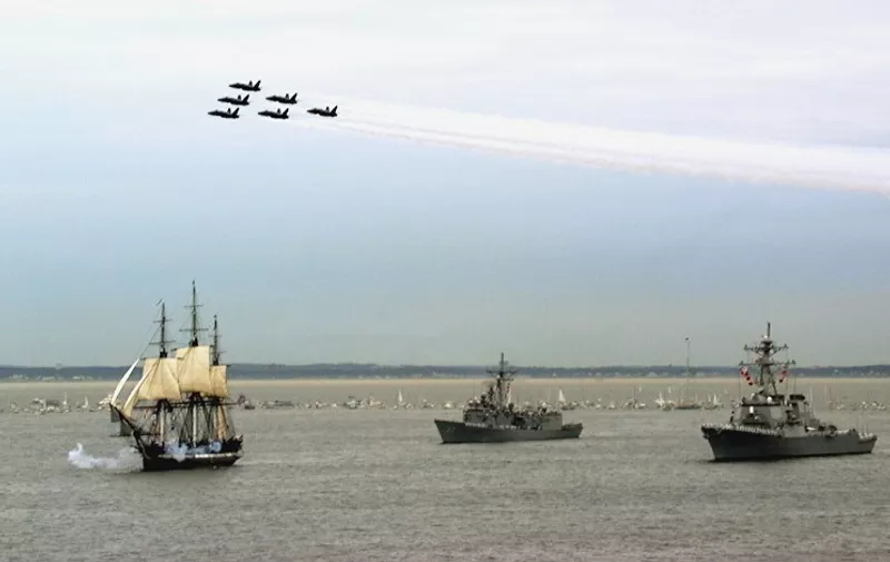 The USS Constitution (L), the worlds oldest commissioned war ship, fires its port and starboard guns while under sail in Massachusetts Bay, MA, 21 July.  Constitution is escorted by the frigate USS Halyburton (FFG 40) (C) and the destroyer USS Ramage (DDG 61) (R), while the Navy's "Blue Angels" Flight Demonstration Squadron passes overhead.  Commissioned on 21 October, 1797, Constitution set sail unassisted for the first time in 116 years.  AFP PHOTO/US NAVY/Todd STEVENS
 / AFP PHOTO / US NAVY / TODD STEVENS