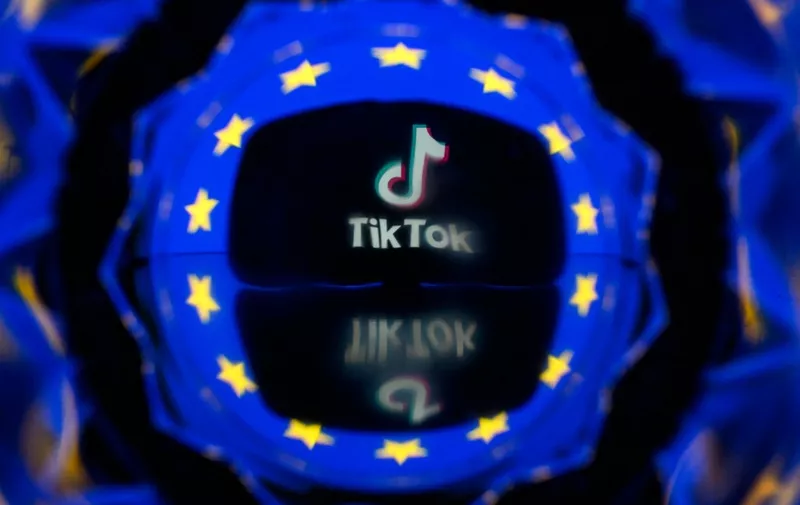 This picture taken on April 26, 2023 in Toulouse, southwestern France, shows a screen displaying the Tiktok social media platform's logo and the European flag. European commissioner for the Internal Market Thierry Breton unveiled a list of 19 online platforms, including Instagram, TikTok and Twitter, as having user numbers so big they will come under stricter regulatory rules for content. The list which also includes services from Amazon, Google, Meta, Instagram and Microsoft puts them in a category under a new EU law, known as the Digital Services Act (DSA), imposing measures from August such as annual audits and a duty to effectively counter disinformation and hate content. (Photo by Lionel BONAVENTURE / AFP)