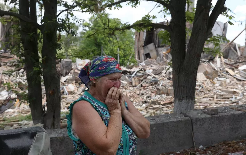 Ukrainian inhabitant, Raisa,  reacts next to a destroyed school in the village of Bilogorivka not far from Lysychansk, Lugansk region, on June 17, 2022. (Photo by Anatolii STEPANOV / AFP)