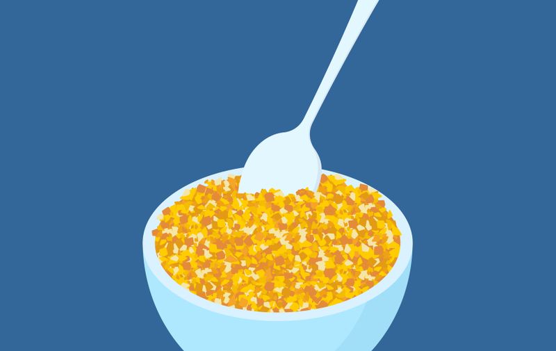 Bowl of corn porridge and spoon isolated. Healthy food for breakfast. Vector illustration