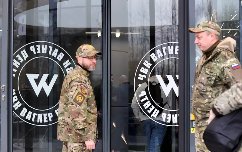Visitors wearing military camouflage stand at the entrance of the 'PMC Wagner Centre', associated with the founder of the Wagner private military group (PMC) Yevgeny Prigozhin, during the official opening of the office block on the National Unity Day, in Saint Petersburg, on November 4, 2022. (Photo by Olga MALTSEVA / AFP)