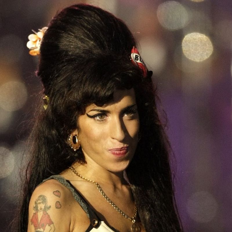 (FILES) In this file photo taken on June 27, 2008 British singer Amy Winehouse performs during the 46664 concert in honour of Nelson Mandela's 90th birthday in Hyde Park, central London - Amy Winehouse may still be best known for her line: "They tried to make me go to rehab. But I said no, no, no."  But 10 years after the British singer's death at 27, her family and friends say it is time to stop defining her by her well-documented struggles with addiction and destructive relationships. (Photo by SHAUN CURRY / AFP)